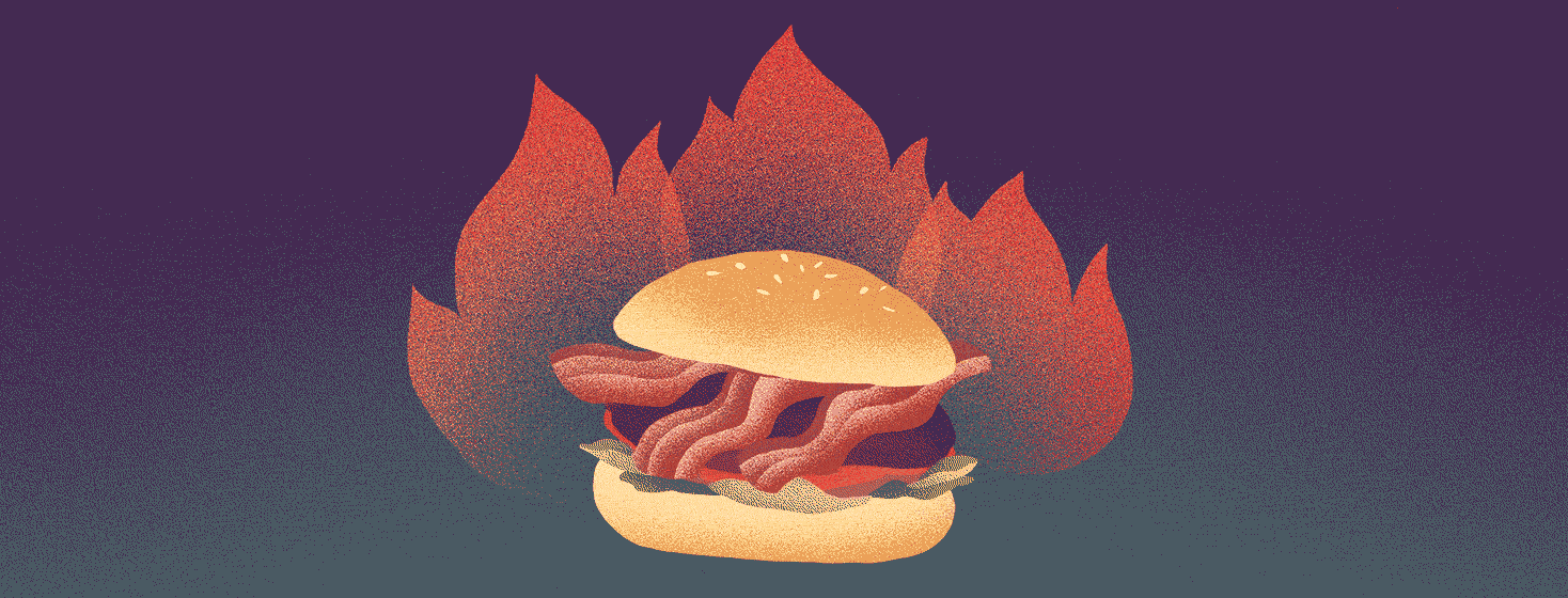 A large bacon hamburger is on fire.
