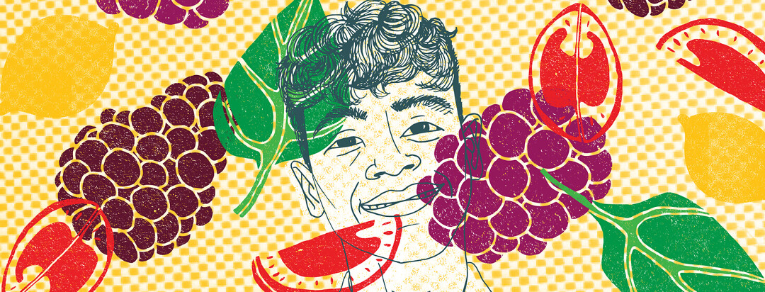 young man smiling shown with colorful fruits and vegetables surrounding him, healthy eating to reduce the odds of prostate cancer.
