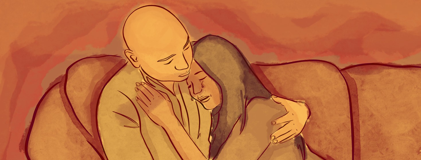 A crying woman leaning into the embrace of her partner, a person with a bald head.