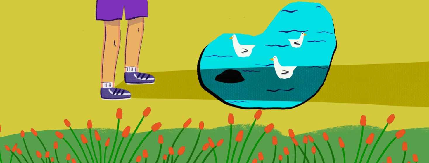 A man stands near a prostate shaped pond, casting a shadow across it and hiding a rock.